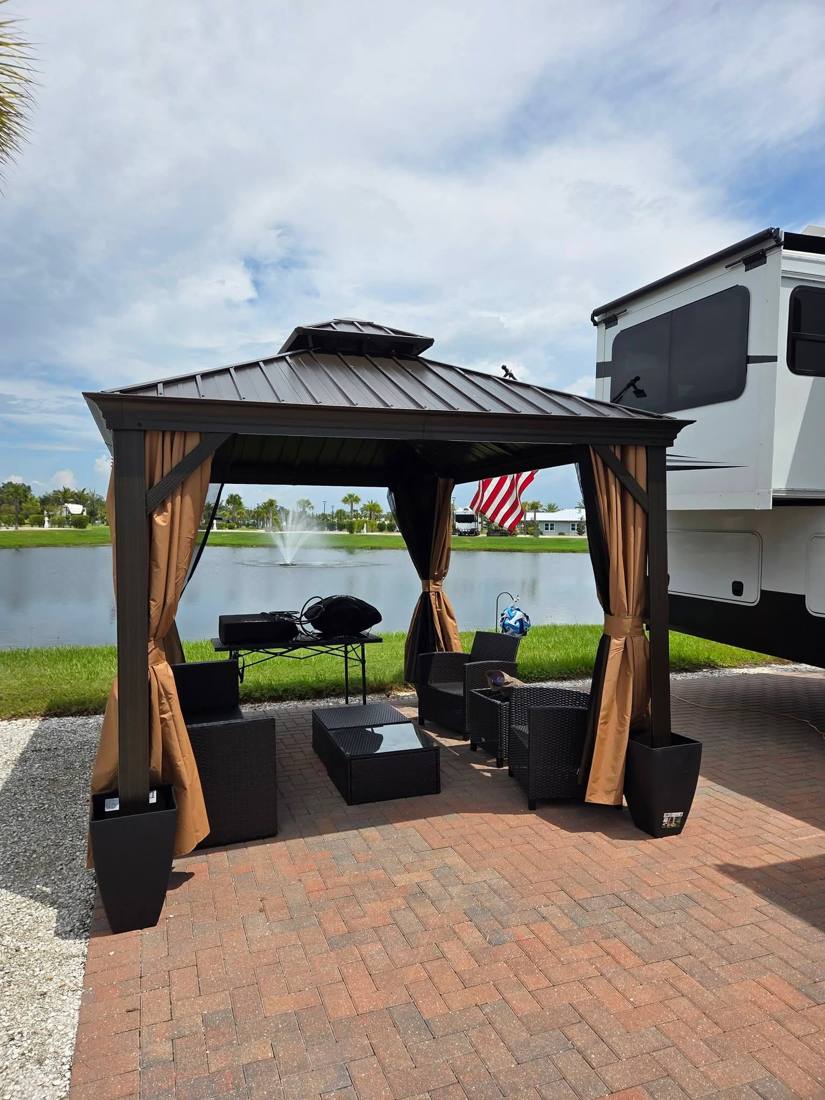 Hardtop gazebo assembled on a paver patio by a lake