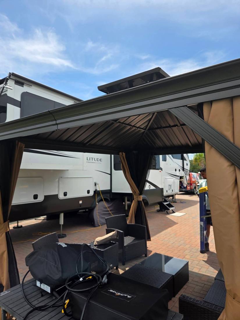 Gazebo installed beside an RV with patio furniture